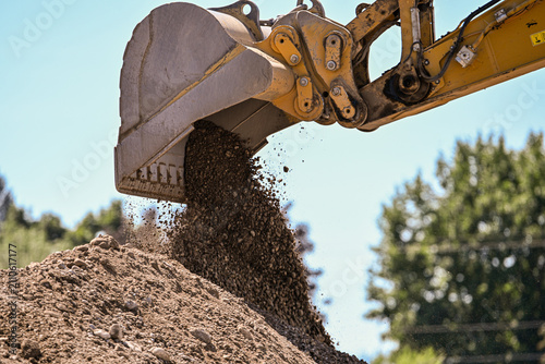 Excavator Bucket Dumping Gravel at Construction Site