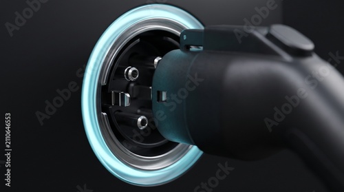 Electric vehicle charging plug inserted into glowing socket connector