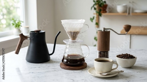 Manual pour-over coffee set with black gooseneck kettle, glass dripper, and grinder on marble table