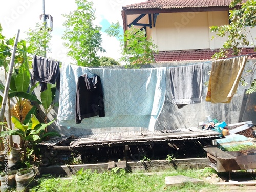Laundry Hanging on Clothesline Under Bright Sun in Residential Backyard – Everyday Household Chores and Sustainable Air Drying
