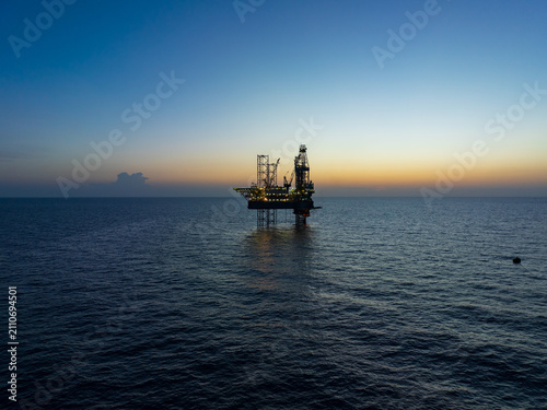 Aerial view of offshore jack up rig and offshore platform during sunset