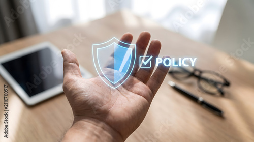 Hand holding glowing digital shield with policy text, corporate insurance and security compliance, Corporate privacy policy and data protection concept,