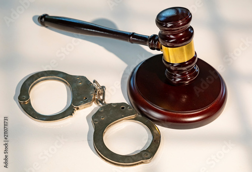 Fotografía Court gavel and handcuffs placed on table during legal proceedings