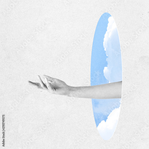 Abstract collage illustration of hand extending from a grayscale world through a vibrant sky portal with clouds. Grunge, motion, noise and blur effect applied