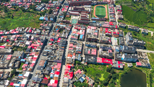 Konstfotografi Aerial view of densely packed rural houses with a school playground and surround