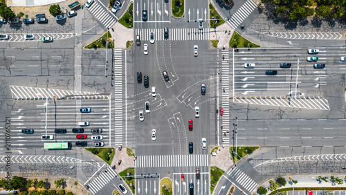 Bild auf Leinwand Aerial view of urban crossroad with heavy vehicle traffic and pedestrian crossin