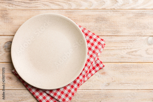 Top view on colored background empty round white plate on tablecloth for food. Empty dish on napkin with space for your design
