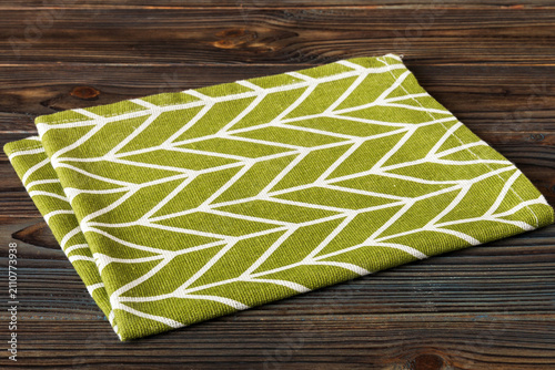 top view with green kitchen napkin isolated on table background. Folded cloth for mockup with copy space, Flat lay. Minimal style