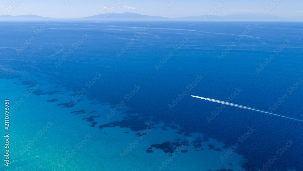 Fototapeta premium Aerial view of boat speeding over turquoise sea