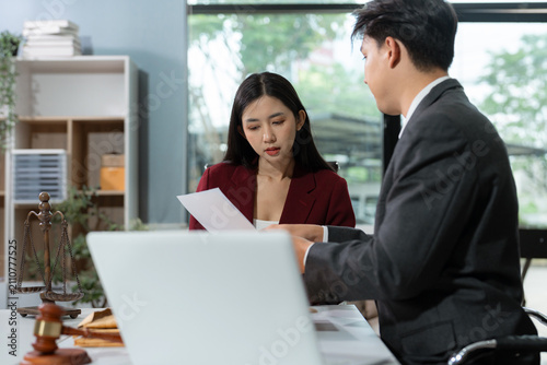 legal counsel reviewing paperwork at a desk in an office, working with a tablet on law and justice matters. Professional attorney in a corporate legal.