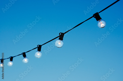 String of party lights against clear sky at twilight