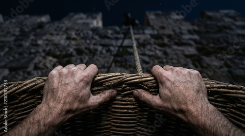 The Apostle Paul escaping assassination in Damascus by being secretly lowered down the outside of the city wall in a large woven basket