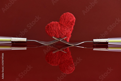Composition of objects,
forks intertwined with a heart,
a symbol of love for cooking and food.
Red background