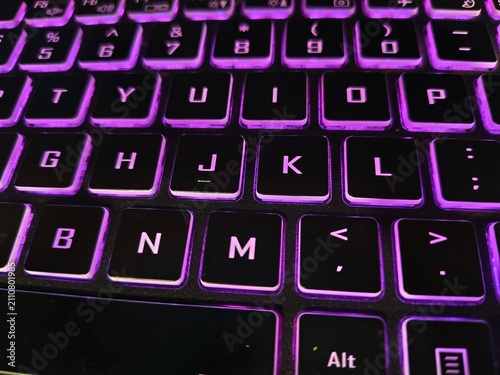 Obraz na płótnie Close-up detail of qwerty gaming keyboard with purple led illumination keyboard