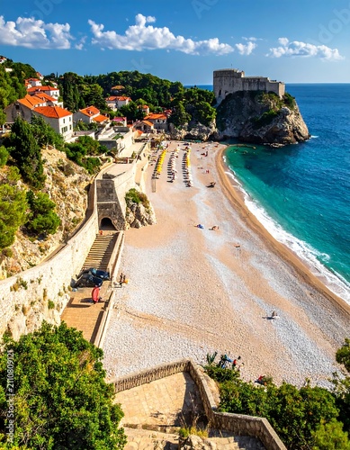 Aerial view of a stunning beach nestled in a bay, with a historic fortress perched atop a cliff, clear sea