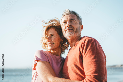 Smiling blond woman with man at beach on sunny day