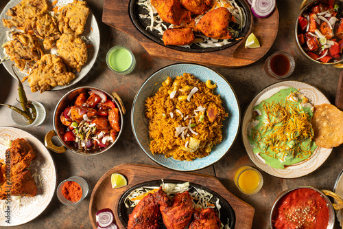Bild auf Leinwand Overhead hero shot of an authentic Indian food spread featuring chicken biryani,