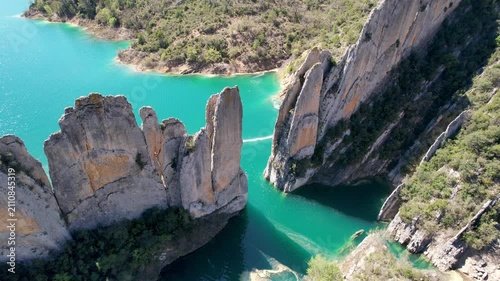 Bird's eye view aerial footage of Muralla de Finestres and Canelles Reservoir on spring day. Huesca, Spain.
