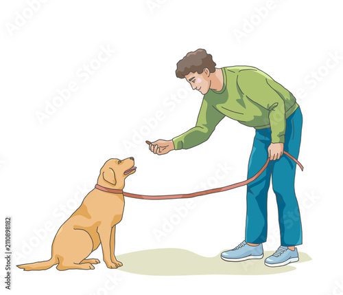 Dog owner training dog with treat during obedience session