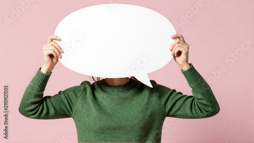 Person holding blank speech bubble, symbolizing communication, feedback, or anonymity with copy space
