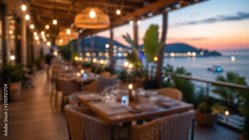 Blurred outdoor restaurant terrace sunset ocean view luxury dining background warm lighting