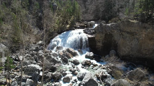 Forward reveal aerial shot of Arripas Waterfall (Cascada de Arripas) in Ordesa y Monte Perdido National Park on sunny spring day. Huesca, Spain.