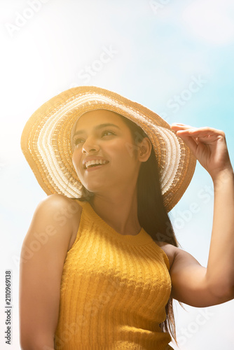 Fotografie PORTRAIT OF A YOUNG WOMAN WEARING HAT AND POSING IN FRONT OF CAMERA