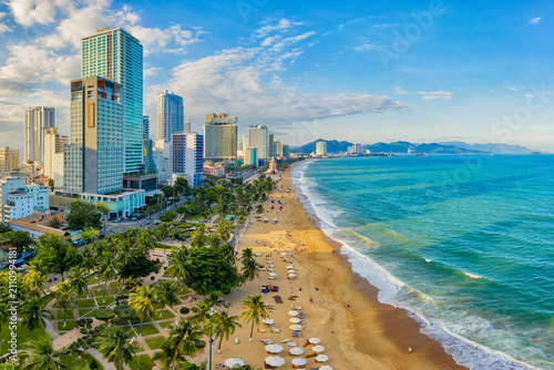 Photography Aerial view of bustling coastal cityscape with sandy beach, palm trees, and modern skyscrapers Nha Trang, Khanh Hoa, Vietnam