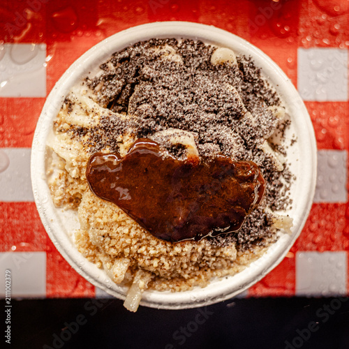 Dessert bowl with powdered sugar and caramel drizzle on checkered clot