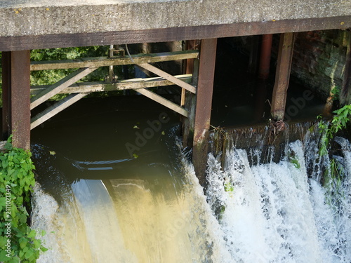 Foto A flood control structure with a sluice gate used to regulate the water level and flow of a river or canal