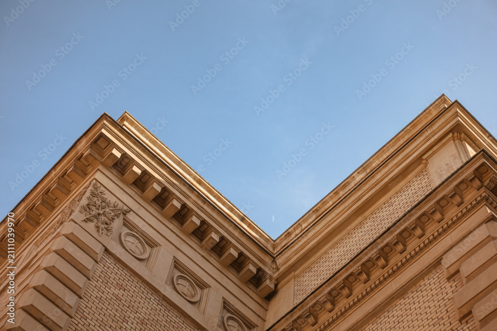 Obraz premium Historic Building Corner with Crescent Moon in Blue Sky