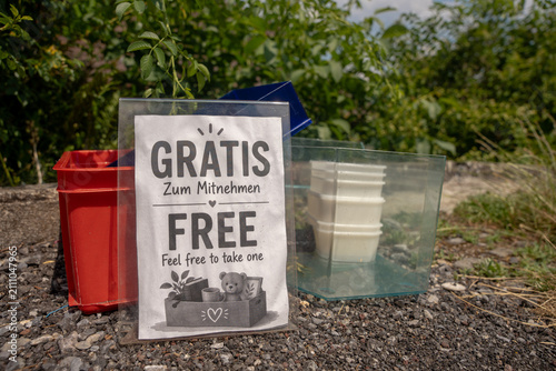 Free giveaway sign in German and English outdoors on a street pavement in Spiez Switzerland under bright natural daylight
