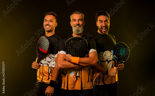 Team of padel tennis player with racket. Men athletes with paddle racket on court with neon colors. Sport concept. Download a high quality photo for the design of a sports app or betting site.