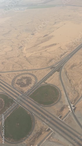 Aerial Top-Down View of Highway Junction Interchange and Roads Passing Through Arid Desert Sand Dunes, Shot from Airplane Window