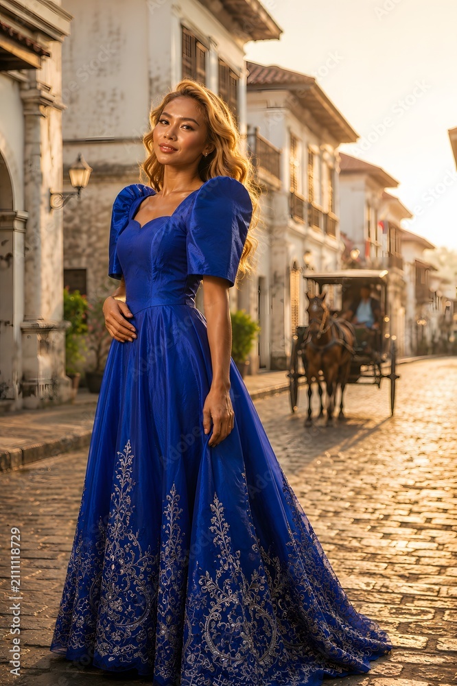 Fototapeta premium Woman in Royal Blue Gown on Cobblestone Street with Horse Carriage in
