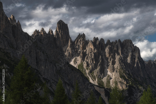 Foto Dramatic alpine mountain range with sharp rocky peaks under dark stormy clouds