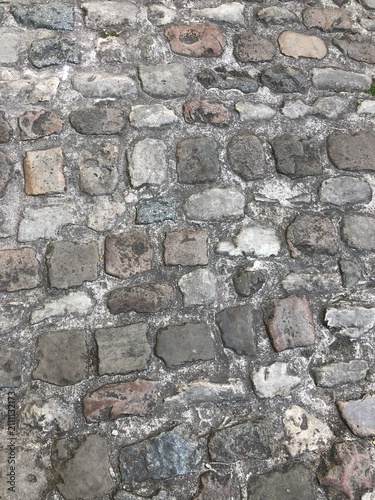 European Weathered old grey cobblestone paving stones texture blocks masonry background