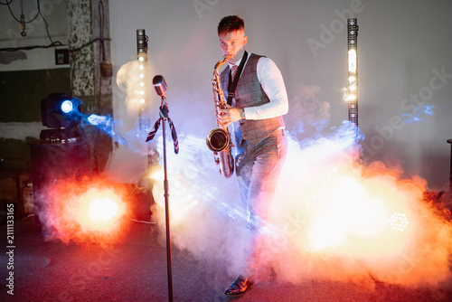 Konstfotografi White man musician playing a saxophone on stage during a night performance surro