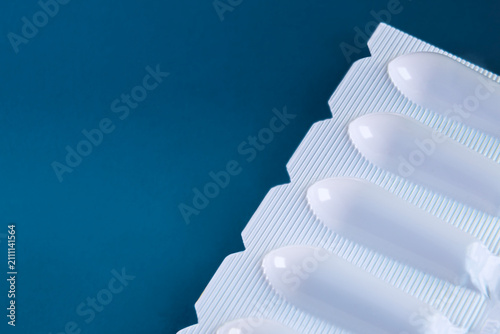 Foto White Suppositories in Blister Pack on Blue Background, Medical Medication Packa