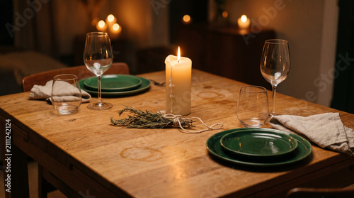 Imperfect winter dinner table, candle, mismatched plates, gathering mood  