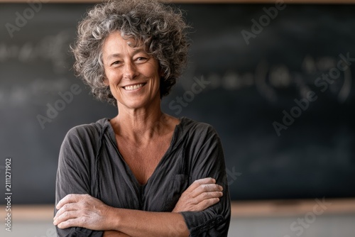 Smiling middle-aged woman with curly hair in classroom setting
