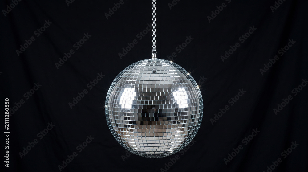 Fototapeta premium Silver disco ball hanging against dark backdrop.