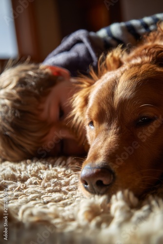 Sleeping child with dog on carpet