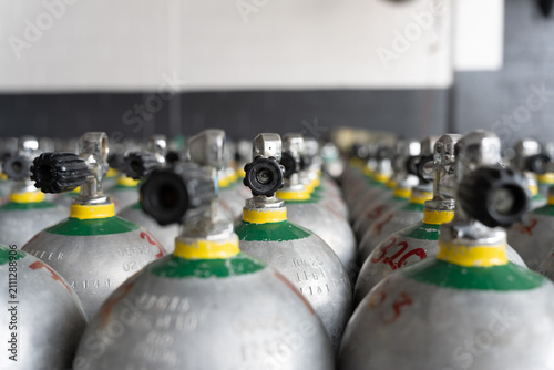 Rows of diving cylinders with valves and gauges ready for underwater activity