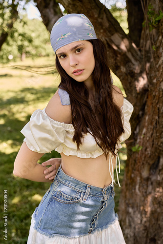 Fotografie Summer charm captured in a serene green landscape with a stylish young woman