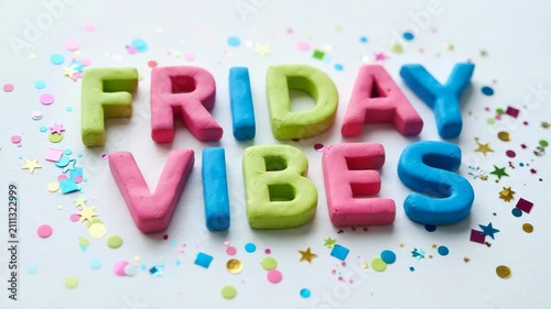 Colorful clay letters spelling friday vibes with confetti scattered on white surface for celebration content