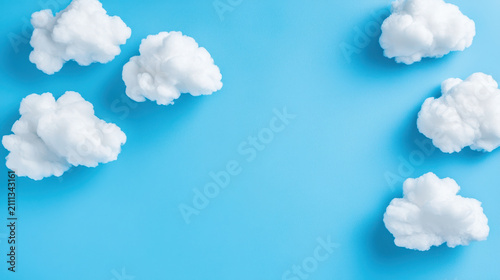 Fluffy white clouds scattered against bright blue background create serene and cheerful atmosphere