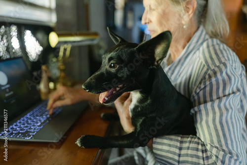 woman sitting at her desk with dog on her lap 