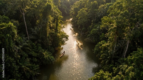 Aerial view of a lone boat on a river in the middle of a lush tropical jungle at golden sunset
