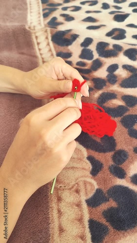  Person holding red yarn for knitting and crochet craft, hands working with fiber thread, handmade hobby.